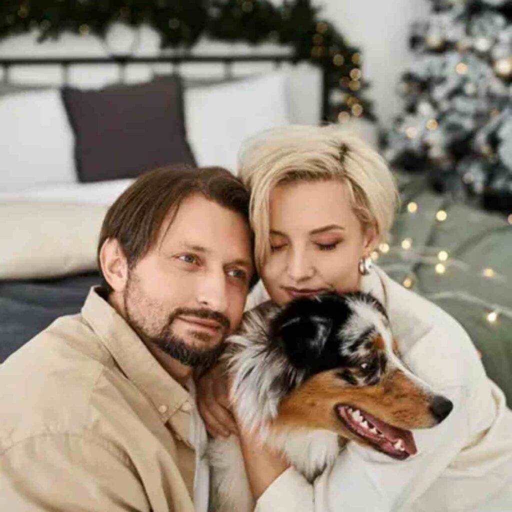 Un couple souriant tenant leur chien dans les bras, symbolisant le Nouvel An à Paris et l’importance des animaux de compagnie pendant les festivités.