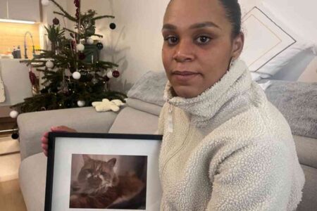 Portrait de Mélissa tenant une photo de son chat Hera, tué par des chiens à Bondoufle, une affaire qui suscite une vive émotion dans le quartier.