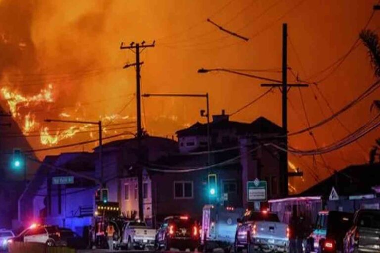Scène de nuit à Los Angeles avec des flammes illuminant le ciel et des véhicules de secours en action lors du 'Palisades Fire'