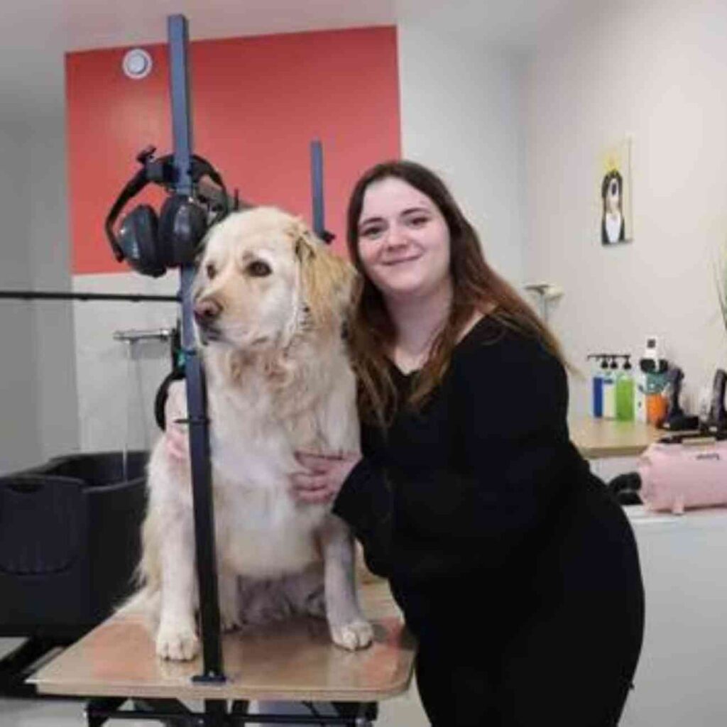 Annaëlle Élie, jeune entrepreneuse de 24 ans, pose avec son chien dans son salon de toilettage Douce Mousse à Guingamp