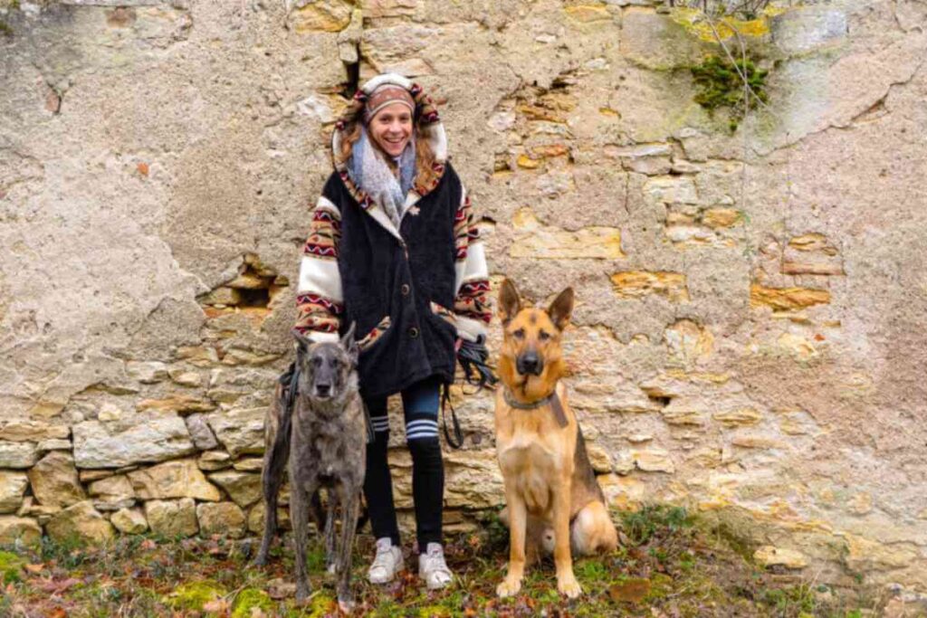 Femme promenant deux chiens en pleine nature, illustrant son service de Pet Sitting à Cahors.