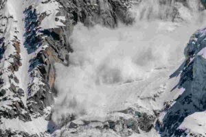 Secouriste et chien de sauvetage fouillant dans une zone de montagne enneigée après une avalanche en Norvège