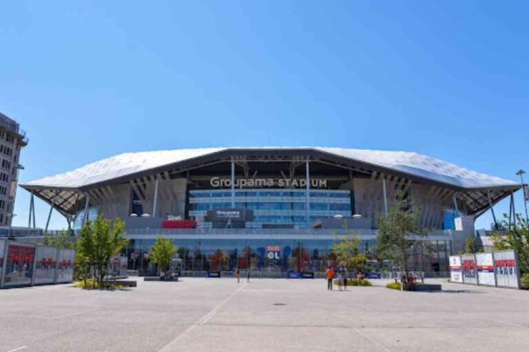 Entrée principale du Groupama Stadium sous un ciel dégagé, vue frontale de l’infrastructure