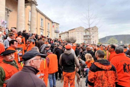 Rassemblement de chasseurs en gilets orange devant un tribunal en Ardèche