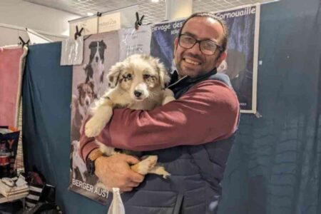 Un éleveur tenant un chiot lors du Salon du chiot à Orléans, édition avril 2025 – événement familial dédié à l’adoption responsable.