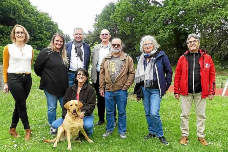 Toffee, chienne labrador, posant avec les membres de l’équipe de l’IME Kergadaud sur la pelouse de l’établissement.
