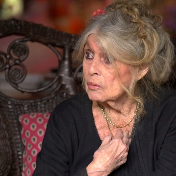 Brigitte Bardot assise, visage grave, appelant à protéger les animaux oubliés pendant les vagues de chaleur en France.