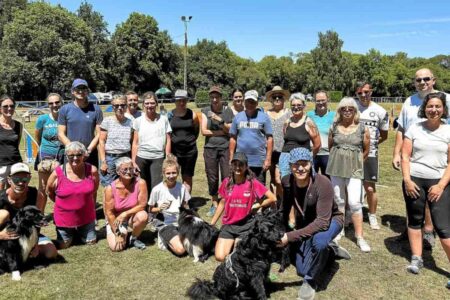 Photo de groupe en plein air avec les bénévoles du concours agility de Vannes, au parc du Pérenno, accompagnés du juge suisse Sasha Grunder et de son chien Shuriten