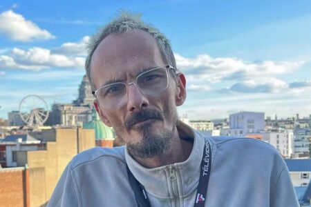 Portrait de Jean Pormanove, streamer français décédé en direct, photographié en extérieur sous une lumière naturelle, en plan rapproché.