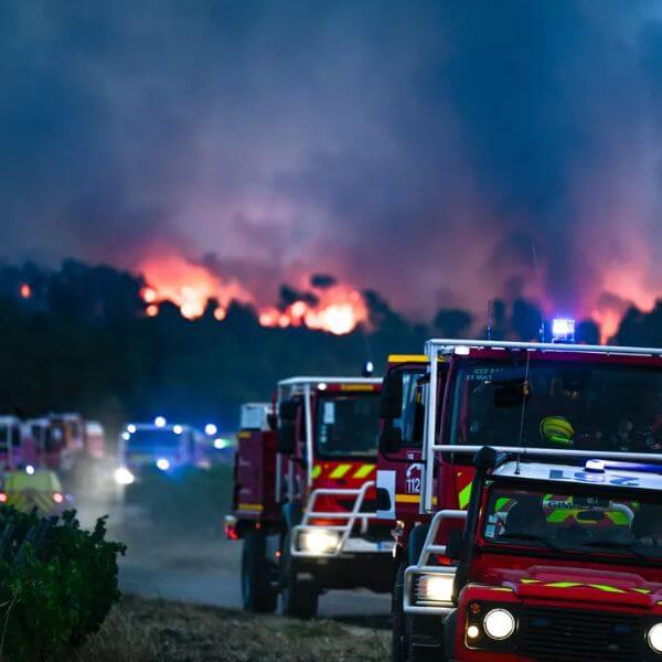 Des camions de pompiers en intervention de nuit face à un incendie géant dans l’Aude.