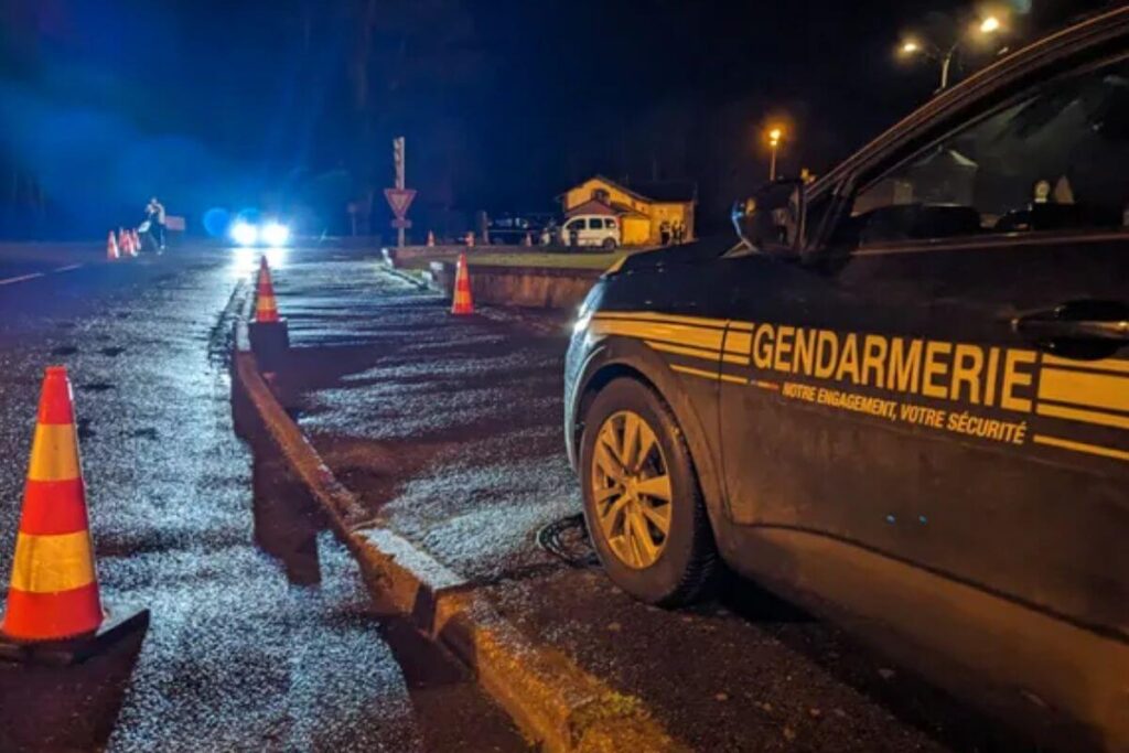 Voiture de gendarmerie et cônes de signalisation lors d’une interpellation de nuit