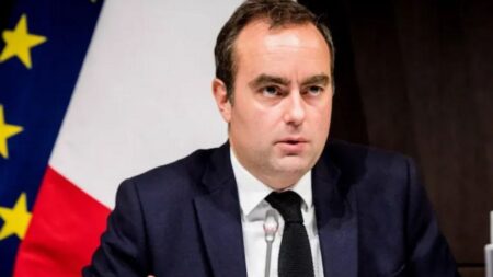 Texte alternatif : « Un représentant du gouvernement français lors d’une conférence de presse, illustrant la reconduction du même leadership politique évoquée dans l’article de Planipets Média. »