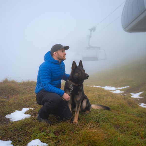 Chiens d’avalanche : ces héros silencieux qui veillent sur la montagne 2 Illustration d’un maître-chien d’avalanche et de son chien en montagne, symbolisant la complicité et la vigilance avant la saison hivernale – Crédit photo : Planipets Média